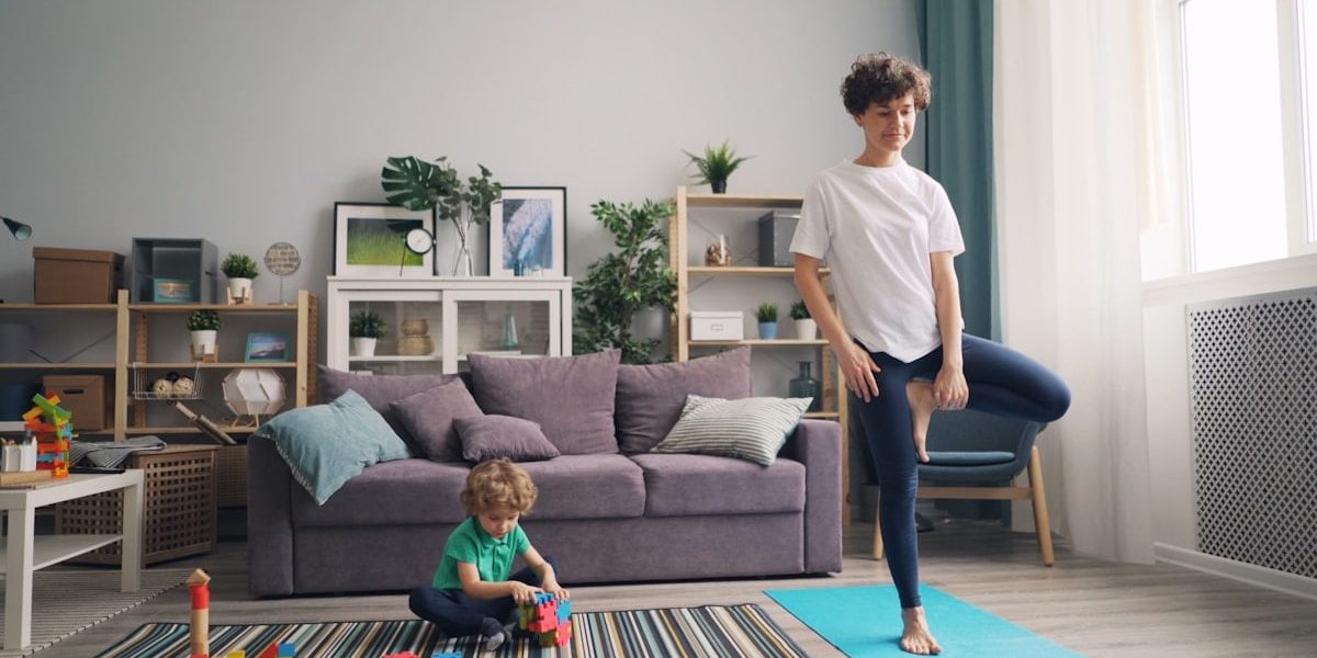 a woman standing in a living room next to a child